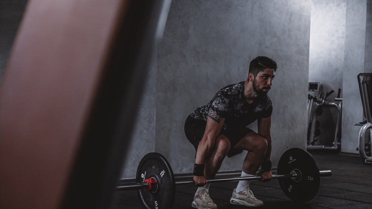 Man lifting weights in gym, displaying strength and focus. Ideal for fitness and training themes.